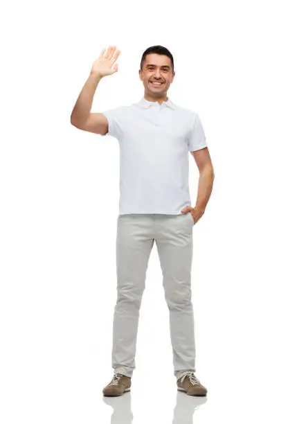Photo of smiling man in blank white t-shirt waving hand
