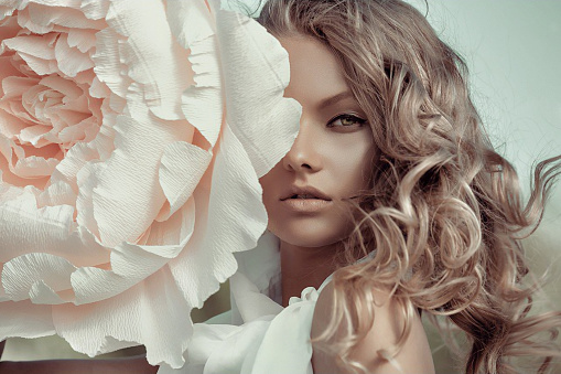 Beautiful portrait of a woman with big paper flowers