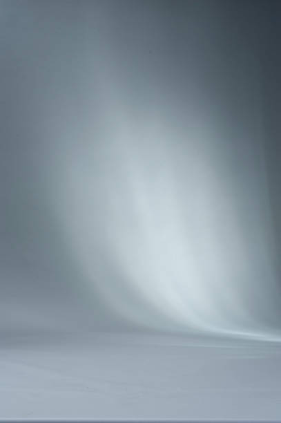 istock Shadows and beams of lights on a white studio backdrop. 1213236871