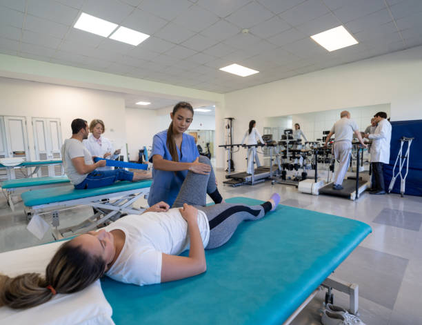 istock Physiotherapist helping woman doing stretching exercises for her leg 1213238585