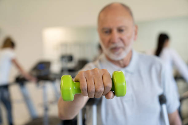 istock Senior man lifting weights while exercising in physiotherapy 1213238622