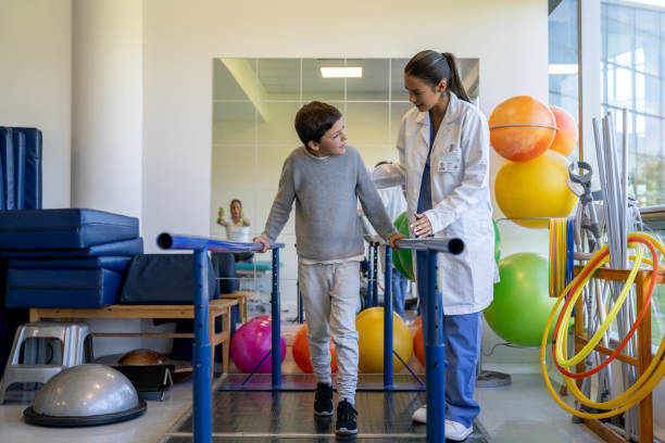istock Boy doing physiotherapy at a clinic with help of a therapist 1213238676