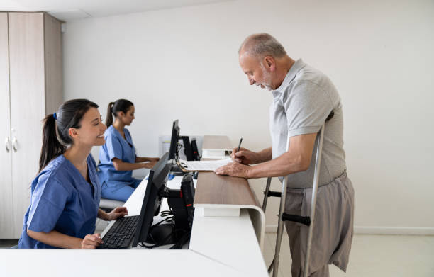 istock Friendly receptionist helping disabled man filling forms at the hospital 1213241463