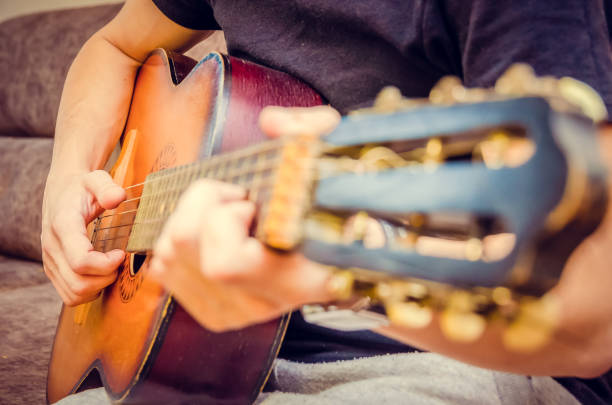 istock man plays a brown guitar in close-up 1213241489