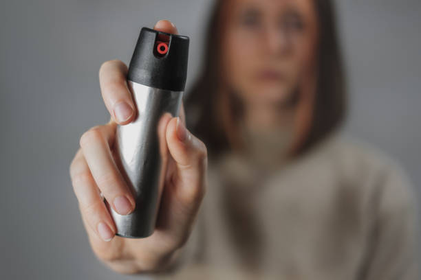 mujer con un spray de pimienta, vista de cerca - pulverizador de pimienta fotografías e imágenes de stock