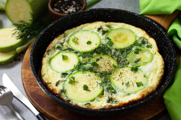 istock Breakfast. Summer omelet with zucchini and herbs on a stone or slate table. 1213242804