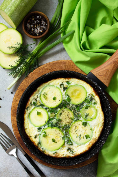 istock Breakfast. Summer omelet with zucchini and herbs on a stone or slate table. Top view flat lay. 1213242812