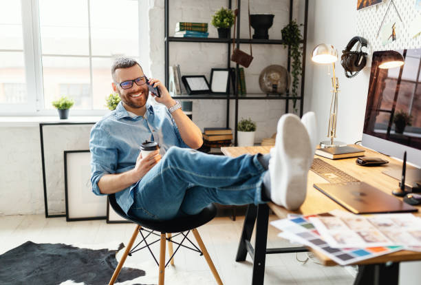 istock Young man is talking on the phone   at workplace 1213243042