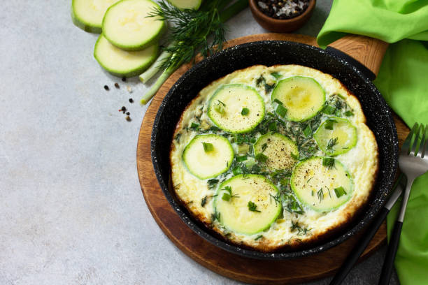 istock Breakfast. Summer omelet with zucchini and herbs on a stone or slate table.  Copy space. 1213243660