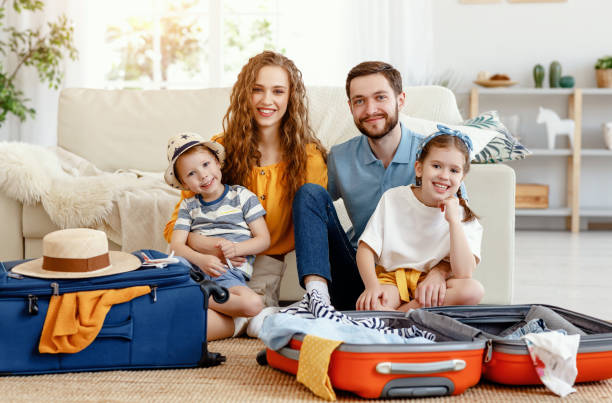 istock Cheerful family with suitcases on floor looking at camera 1213243985