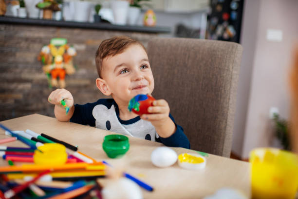 istock Little boy painting Easter eggs stock photo 1213246162