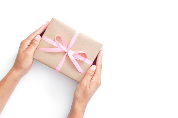 istock Female hands holding present box or gift box package in craft paper 1213247489