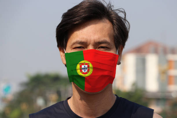 Portugal flag on hygienic mask. Masked the man prevent germs. Concept of Tiny Particle protection or virus corona. stock photo
