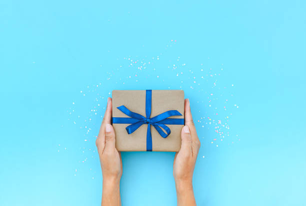 istock Female hands holding present box or gift box package 1213248750