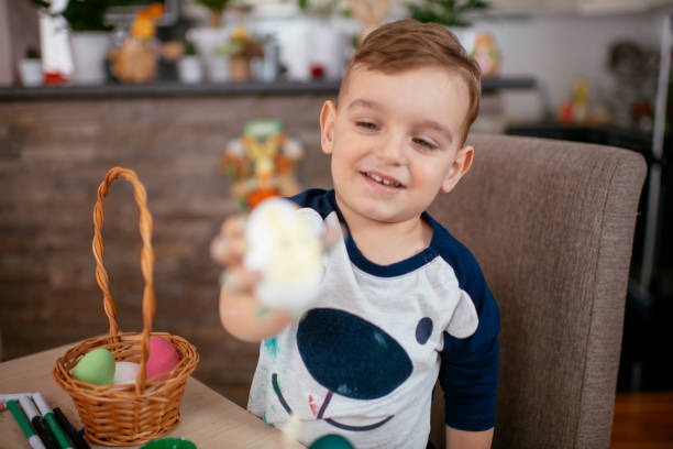 istock Little boy painting Easter eggs stock photo 1213249623