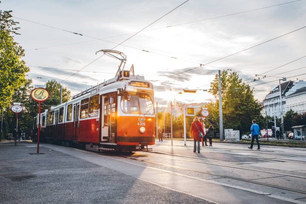 Typical red retro ring tram (Straßenbahn Haltestelle) at the station on a sunny day located in Karlsplatz, Vienna, Austria