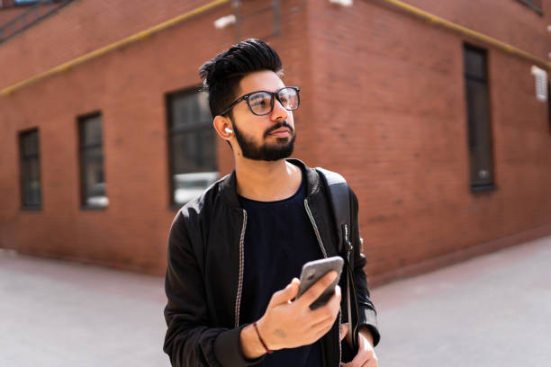 istock Indian man use phone while standing on the street 1213250338