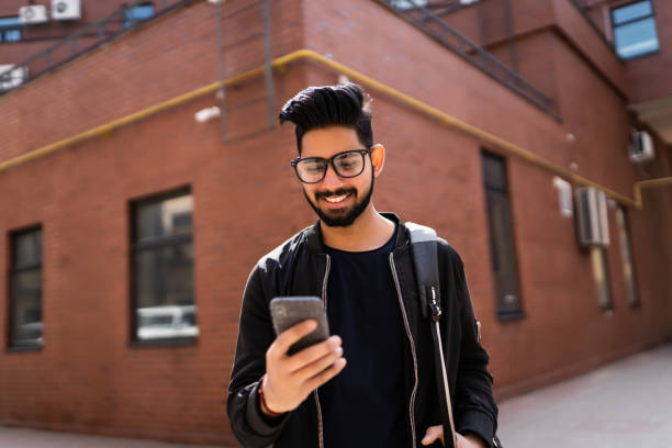 istock Indian man use phone while standing on the street 1213250439