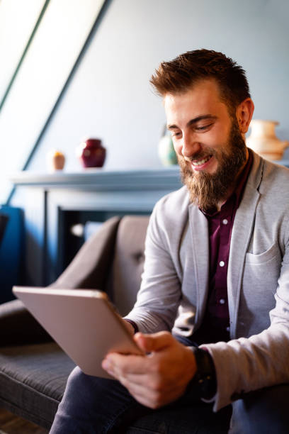 istock Young business man working, relaxing on the sofa with a tablet 1213251070