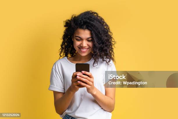 Portrait Of Attractive Young African American Girl Using Mobile Phone Stock Photo - Download Image Now