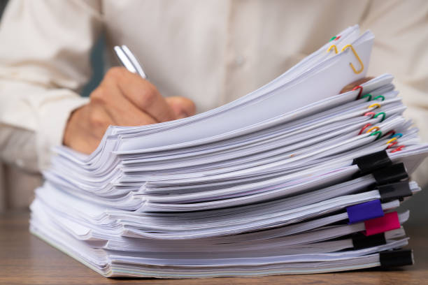 istock Male office workers holding and writing documents on office desk, Stack of business overload paper. 1213256722