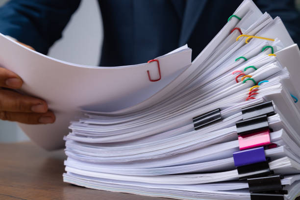 istock Business man hand pick up Stack overload document report paper with colorful paperclip, business and paperless concept. 1213256745