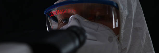 мужчина в защитном костюме биохимика мониторинга китайского коронавируса - gogles стоковые фото и изображения