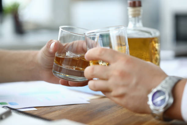 istock Men sit workplace and drink alcohol from glasses 1213258720