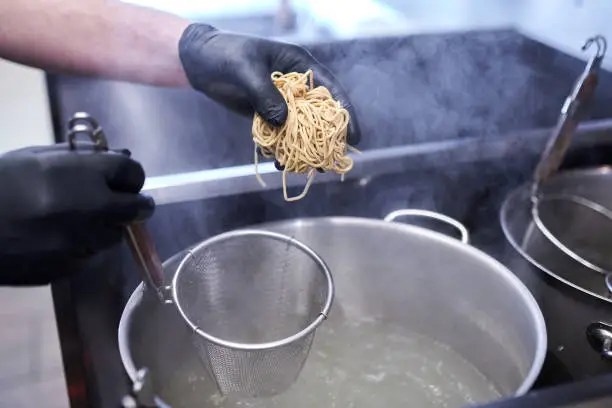 Photo of Cooking asian noodle in hot water in ramen shop