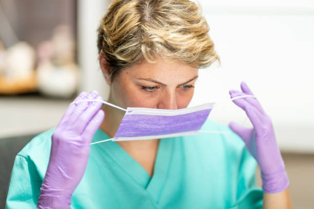 istock Middle aged healthcare worker putting on protective mask 1213259134