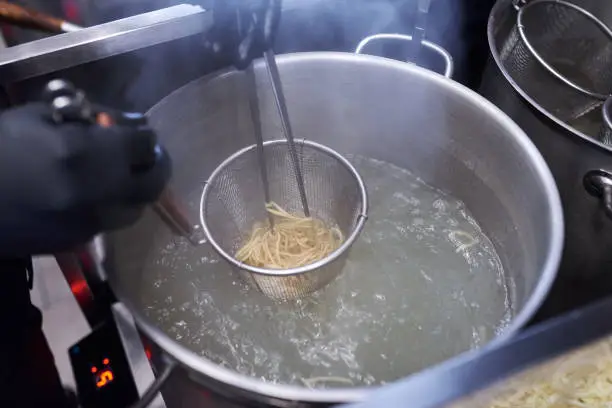 Photo of Cooking asian noodle in hot water in ramen shop