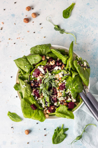 istock Beetroot spring or summer salad with spinach, feta cheese, chickpea, sprouts and hazelnut on plate with fork. Copy space for text. Top view. 1213259760