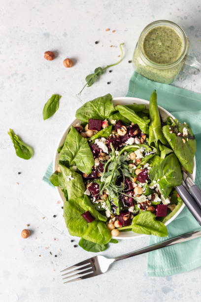 istock Salad with roasted beet, spinach, feta cheese, chickpea, sprouts and nuts on light blue stone background with copy space. Top view. 1213259822