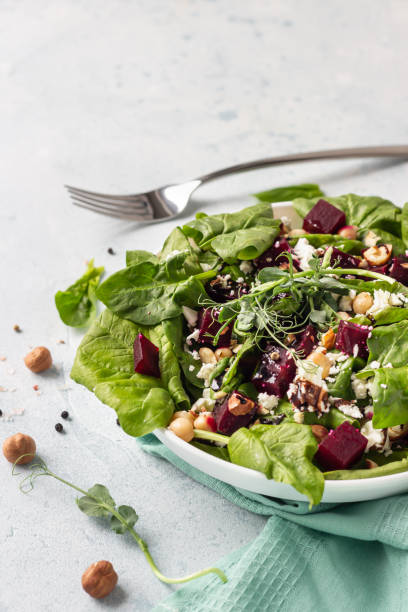 istock Beetroot spring or summer salad with spinach, feta cheese, chickpea, sprouts and hazelnut on plate with fork. Copy space for text. 1213260285