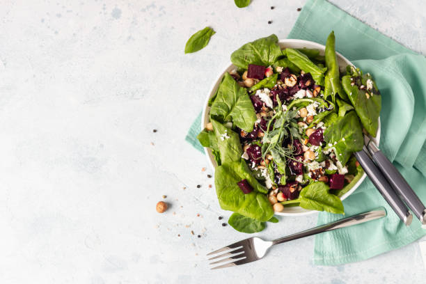 istock Salad with roasted beet, spinach, feta cheese, chickpea, sprouts and nuts on light blue stone background with copy space. Top view. 1213260303