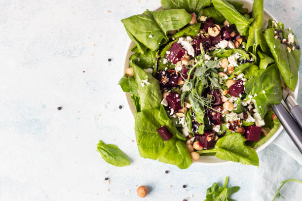 istock Beetroot spring or summer salad with spinach, feta cheese, chickpea, sprouts and hazelnut on plate with fork. Copy space for text. Top view. 1213260816