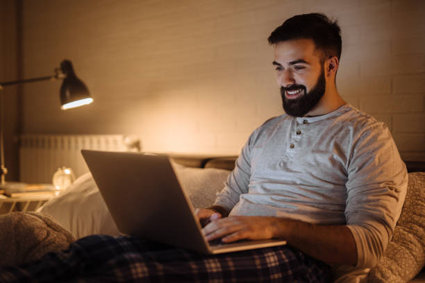 istock Young man working late in bed on a laptop 1213267986