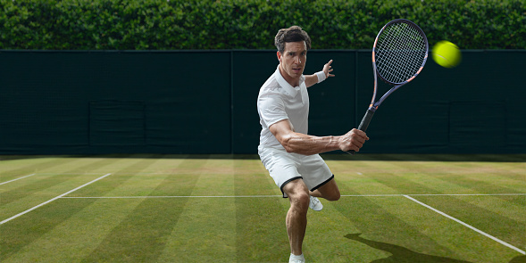 A male tennis player dressed in tennis whites in mid motion, about the hit the ball in a backhand volley during a game of tennis. The athlete is in mid motion and is playing on a grass court in a generic location during a summer day.