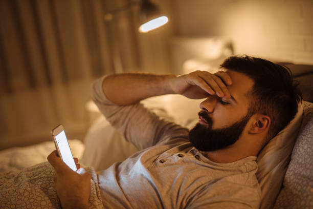 joven preocupado leyendo malas noticias en el teléfono inteligente - men one person surprise looking fotografías e imágenes de stock