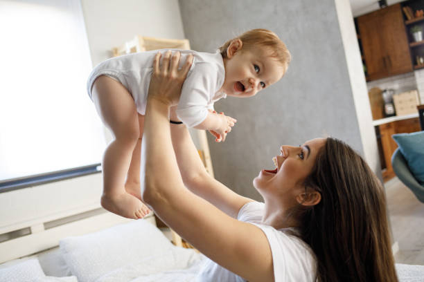 istock Mother playing with her baby boy on bed 1213268563