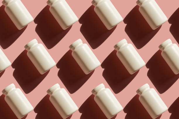 istock Repeating white cans of pills on a pink background 1213270758
