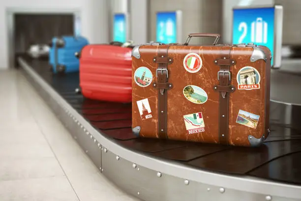 Photo of Old vintage suitcase on a airport luggage conveyor belt. Baggage claim. Travel and tourism concept background.