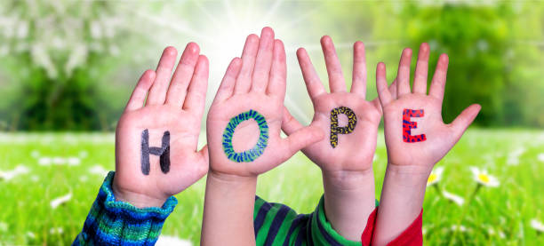 istock Children Hands Building Word Hope, Grass Meadow 1213273259