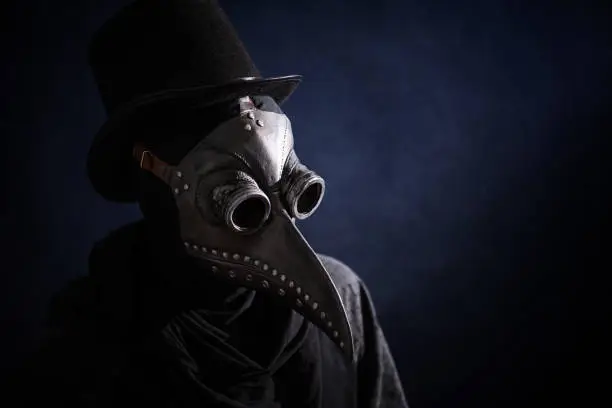 Masked man plague doctor, head profile, with bird mask and hat. Vintage style. Biohazard concept.