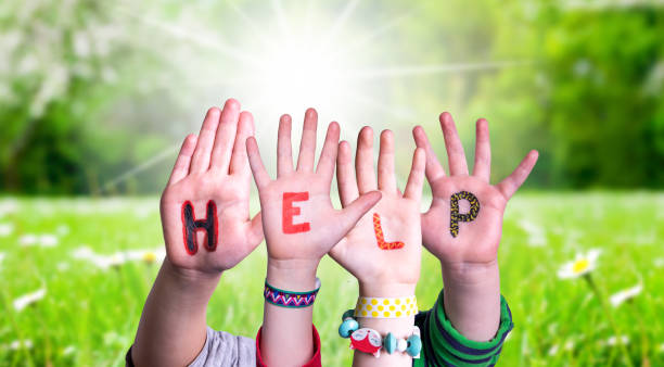 istock Children Hands Building Word Help, Grass Meadow 1213274496