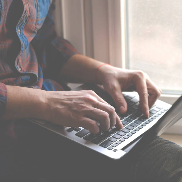 istock Man using laptop in home office. Male hands typing on keyboard 1213277730