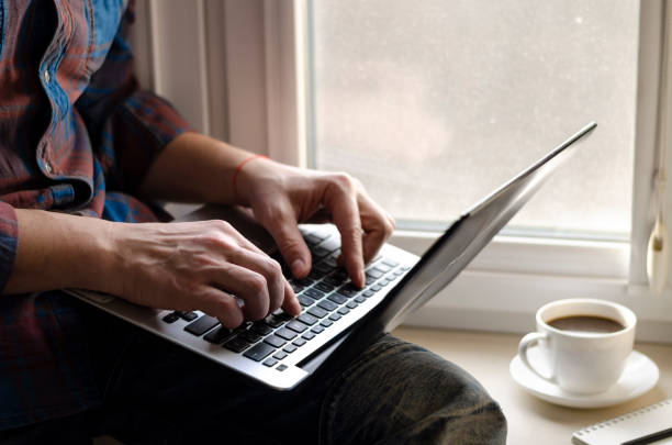 istock Man using laptop in home office. Male hands typing on keyboard 1213277741
