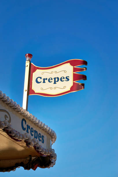 Crepes as text on a sign with blue sky in the background.