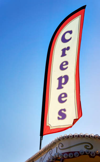 istock Crepes as text on a flag with blue sky in the background. 1213279281