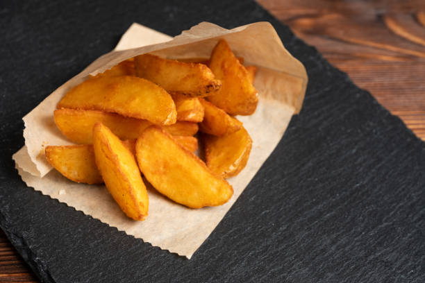 istock Potato rustic tableware slate, black stone on a wooden background. 1213283852